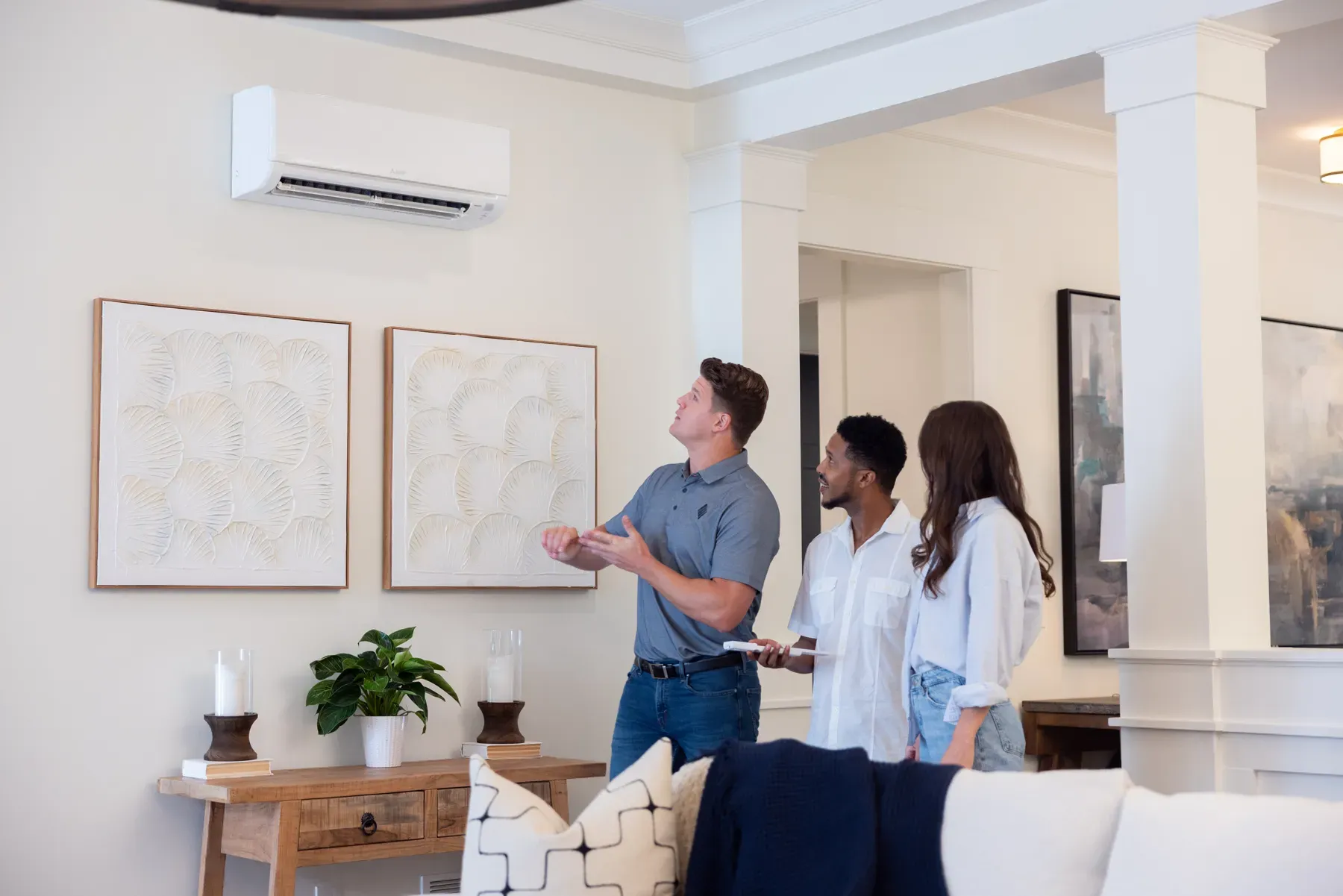 Mitsubishi technician showing a family how to operate the remote controls for the Mitsubishi Electric ductless mini-split.